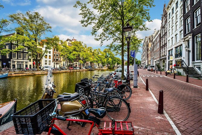 Amsterdam Day Trip from Brussels With Cheese, Clogs and Windmills - Amsterdam orientation: Dam Square, Royal Palace façade, and the canal-side walk